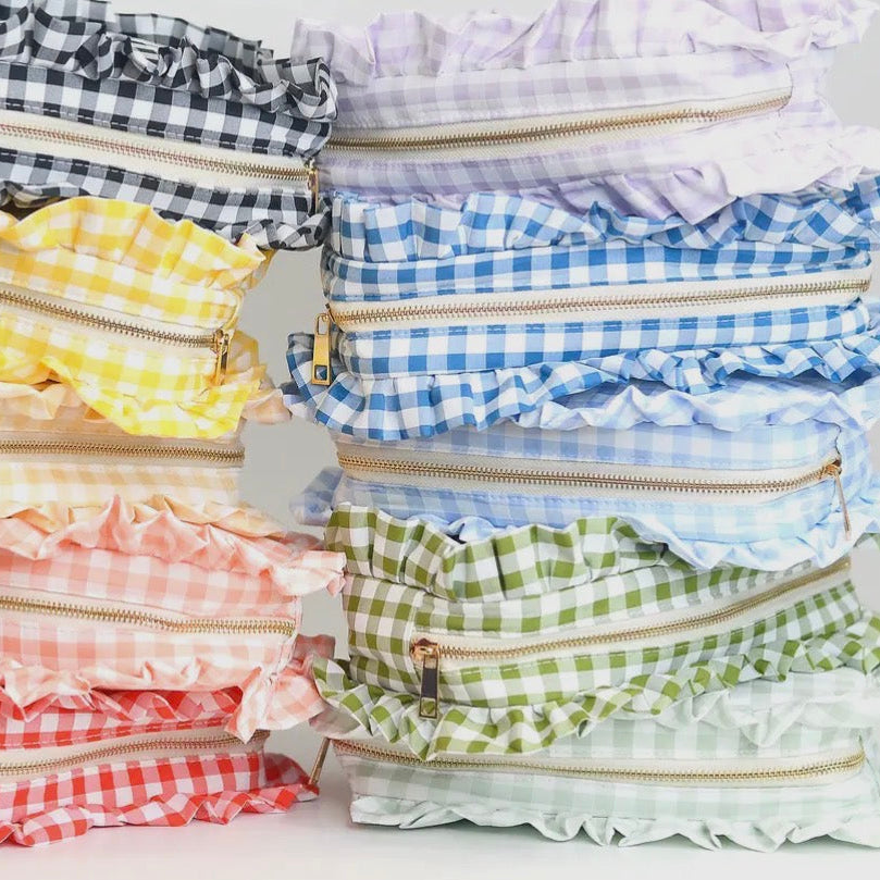 Stack of colorful gingham and checkered fabric swatches on a white background