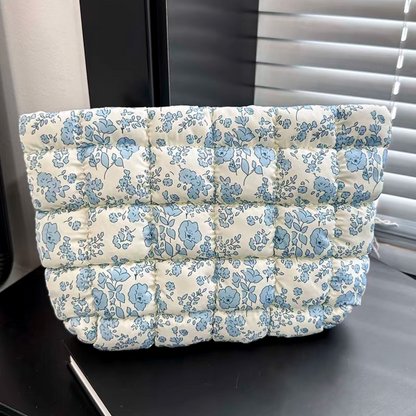 Floral-patterned cushion on a black surface with a window in the background
